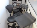 a black chair and a black stool in the corner of a room