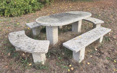 une table et un banc en pierre au milieu d'un champ