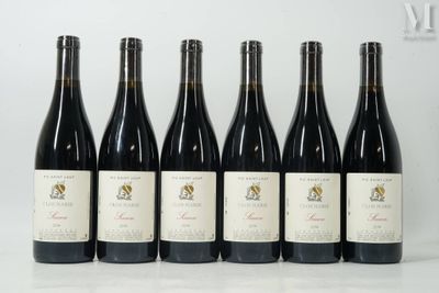 six bouteilles de vin sont alignées sur une table