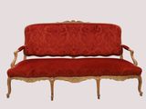 an image of a red couch with a gold frame and red upholstered cushions