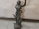statue en bronze d'une femme tenant un oiseau sur un piédestal