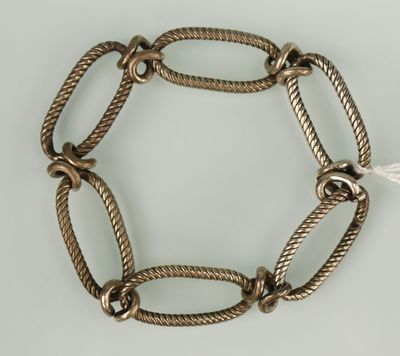 un gros plan d'un bracelet en métal entouré d'une corde