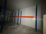 une longue étagère dans un entrepôt, avec des tablettes bleues et orange