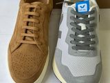 two pairs of sneakers sitting next to each other on top of a table