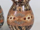 two vases sitting next to each other on a white surface
