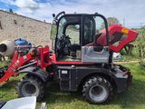 un tracteur rouge garé dans l'herbe