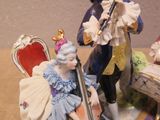 a figurine of a man and a woman playing musical instruments