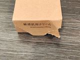 une petite boîte en carton posée sur une table, avec un petit bout de papier dessus