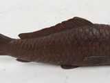 a wooden fish that is sitting on a table