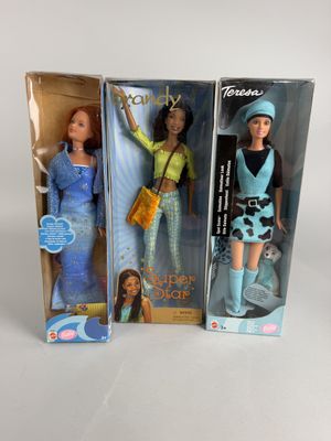Deux poupées Barbie sont présentées dans leur emballage sur une surface blanche.