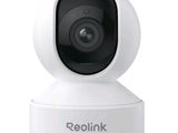 un gros plan d'une caméra posée sur un trépied, sur laquelle figure le mot « Reolink »