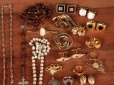 many different types of jewelry on a wooden table