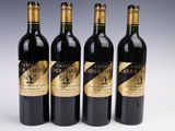 quatre bouteilles de vin sont alignées sur une surface blanche