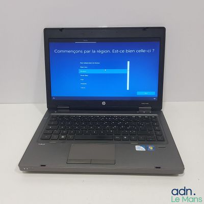 a laptop computer sitting on a table with a blue screen