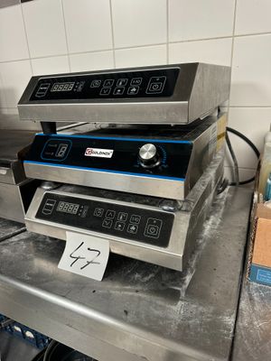 three commercial electric fryers sitting on top of a counter in a kitchen