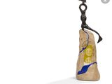 sculpture représentant une femme assise sur un rocher, avec un oiseau posé sur son épaule