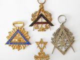 a group of masonic badges including a cross, a compass, and a star