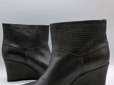 gros plan d'une paire de bottes noires sur fond blanc