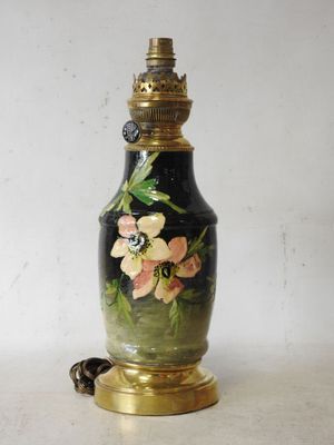 a black and gold vase with flowers painted on it