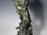 statue en bronze représentant une femme tenant un enfant sur un rocher