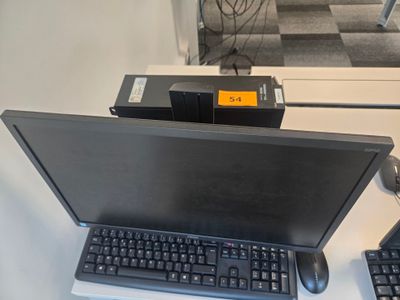 un ordinateur portable posé sur un bureau, à côté d'un clavier et d'une souris