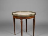 une petite table ronde avec un plateau en marbre et des pieds en bois