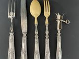 four forks, a knife, and a spoon on a table