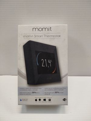 packaging of a black alarm clock sitting on top of a white table