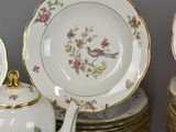 many plates and cups and a teapot on the table