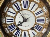 a gold clock with blue and white stripes on the face
