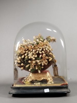 a glass clochet with a vase of flowers inside of it