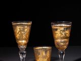 three wine glasses are sitting on a table with a black background