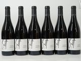 six bouteilles de vin sont alignées sur une table