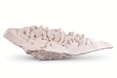 a white sculpture of a leaf with a group of people on it