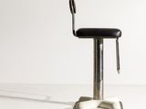 a black stool with a black seat on a white floor