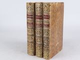 two old books sitting on top of each other on a white surface