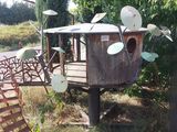 une cabane dans les arbres surmontée d'un nichoir
