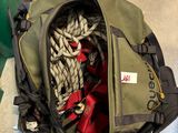 un sac de voyage rempli d'objets, posé par terre