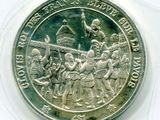 une image représentant une pièce d'argent sur laquelle figure un groupe de personnes