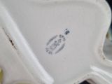 a close up of a white vase with a flower on it