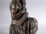 bronze statue of a man sitting on a stool with his hands on his knees