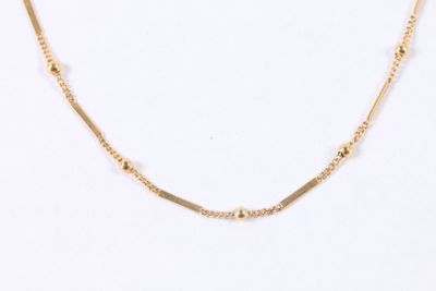 a close up of a gold necklace on a white background