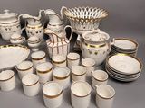 a lot of white and gold dishes and cups on the table