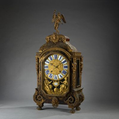 a gold clock with a bird on top of it