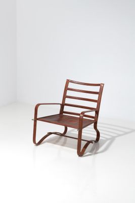 un fauteuil à bascule en bois avec une assise marron, posé sur un sol blanc