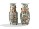 pair of chinese vases sitting on a white surface with a white background