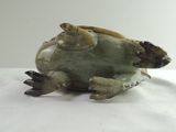 statue of a turtle sitting on its back on a white surface