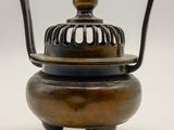 an antique bronze incense pot with a bird cage on top of it