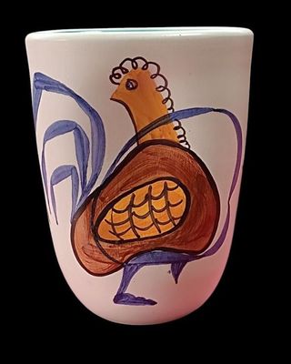 une tasse sur laquelle est peint un oiseau sur fond noir