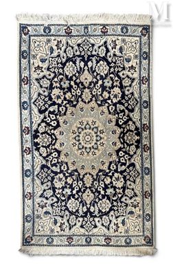 un tapis bleu et blanc orné d'un motif en médaillon